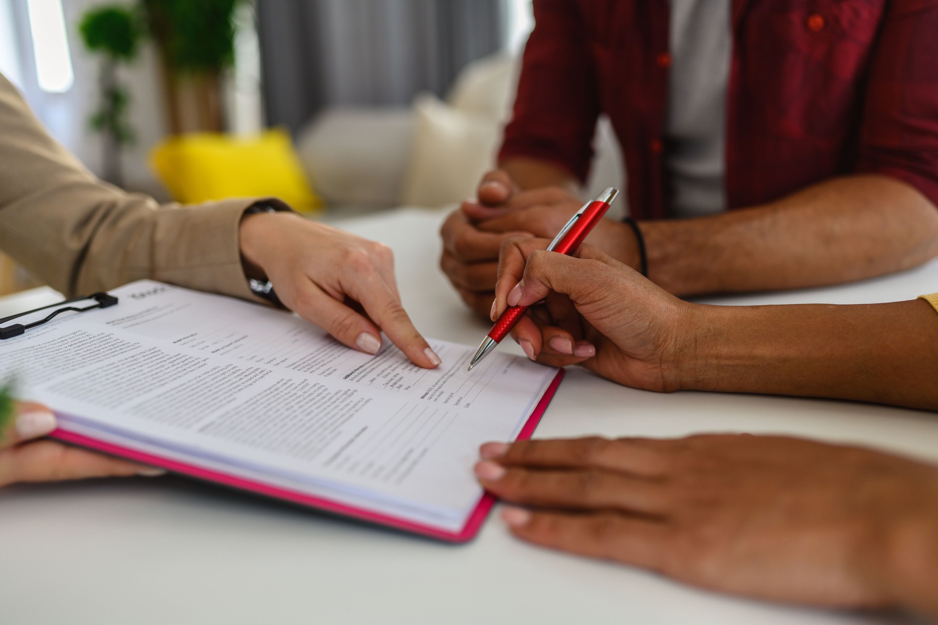 Financial advisor pointing to the form signing of the contract agreement.